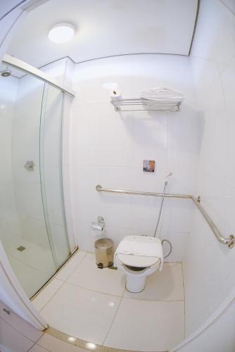 a white bathroom with a shower and a toilet at Profissionalle Hotel São Luís in São Luís
