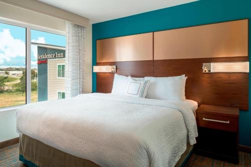 a large bed in a hotel room with a large window at Residence Inn by Marriott Wheeling/St. Clairsville in Saint Clairsville