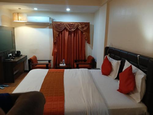 a hotel room with a bed and a red curtain at Hotel Crown in Ahmedabad