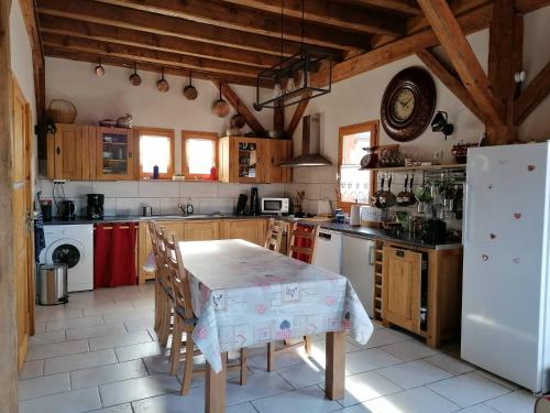 une cuisine avec une table et un réfrigérateur blanc dans l'établissement Chalet La Petite Grange, à Savoie