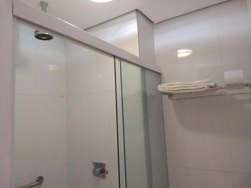 a bathroom with a shower with a glass door at Profissionalle Hotel São Luís in São Luís