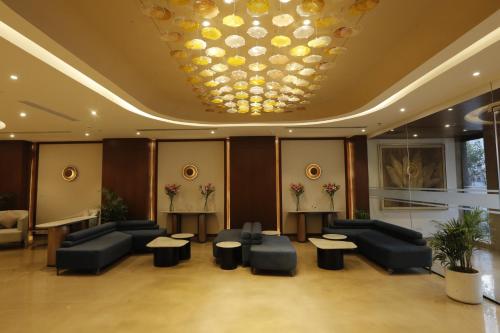 a lobby with couches and tables and a chandelier at Tulip Inn Zirakpur in Chandīgarh