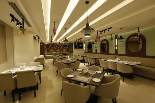 a restaurant with tables and chairs in a room at Tulip Inn Zirakpur in Chandīgarh