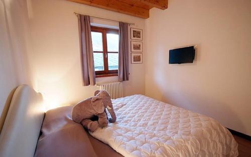 a teddy bear sitting on a bed in a bedroom at Villaggio delle Alpi in Pré-Saint-Didier