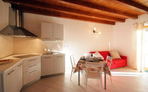 a kitchen with a table and a red couch at Villaggio delle Alpi in Pré-Saint-Didier