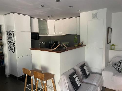 a kitchen with white cabinets and a bar in a room at Les Enganes in Fréjus
