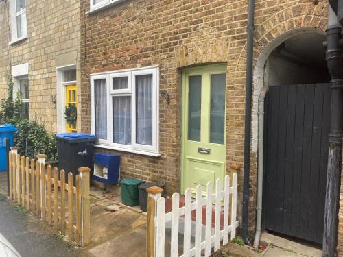 a brick house with a green door and a fence at The Windsor Room in Windsor