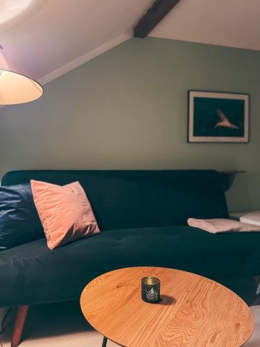 a living room with a green couch and a coffee table at Finnholmen Brygge in Henningsvær