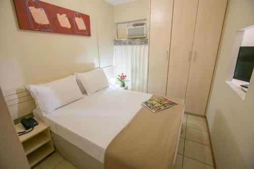 a small bedroom with a bed with a book on it at Verona Hplus Long Stay in Brasilia