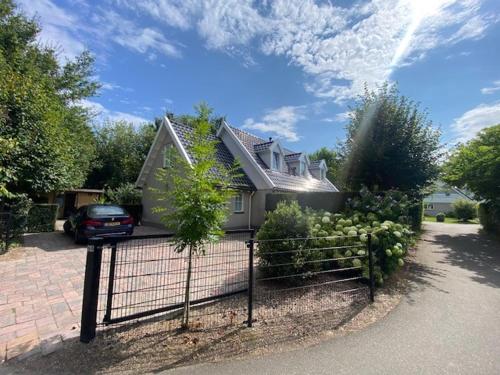 a house with a fence in front of it at Vrijstaande villa met grote tuin, 4 slaapkamers en sauna in Zeewolde