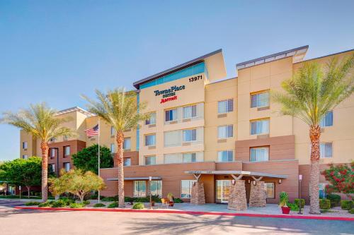 a hotel with palm trees in front of it at TownePlace Suites by Marriott Phoenix Goodyear in Goodyear