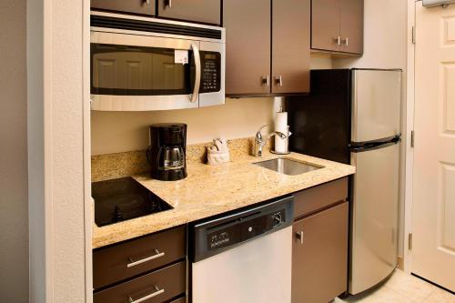 a kitchen with a sink and a microwave at TownePlace Suites by Marriott Phoenix Goodyear in Goodyear