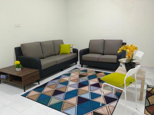 a living room with two couches and a table at IB Homestay Kangar in Kangar