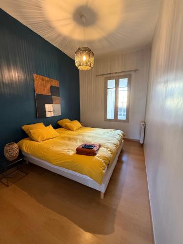 - une chambre dotée d'un lit avec des draps jaunes et un lustre dans l'établissement Vue exceptionnelle sur le canal, à Sète