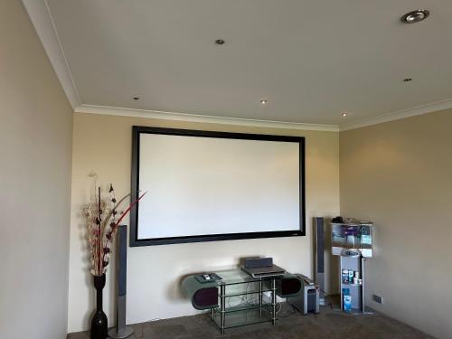 a large white screen on the wall of a room at Country Oasis on Evans Street in Collie