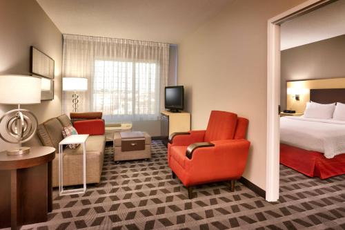 a hotel room with a bed and a couch and chair at TownePlace Suites Omaha West in Omaha