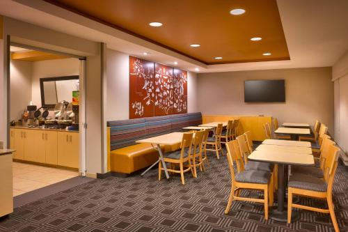 a restaurant with tables and chairs and a kitchen at TownePlace Suites Omaha West in Omaha