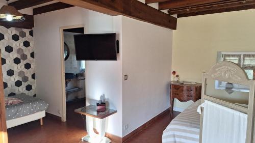 a room with a bed and a tv on the wall at Gîte rural - La Rivière Assoiffée in Florimont-Gaumiers