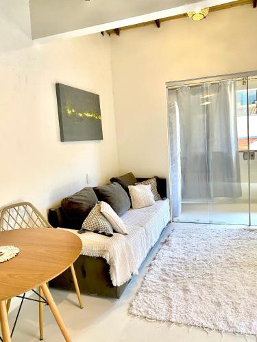 una sala de estar con un sofá y una mesa en Apto 1030, en Trancoso