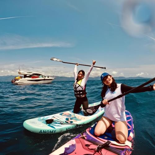 two women on paddle boards in the water at wow夢想家會館 in Green Island