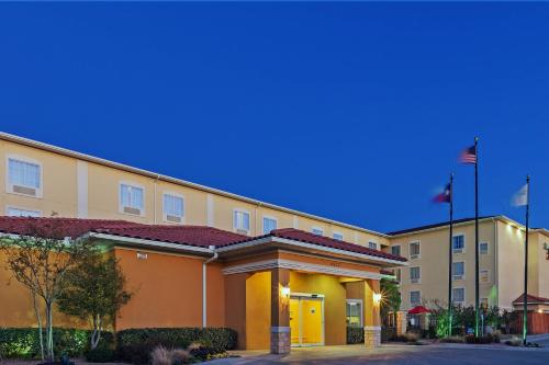 a hotel building with two flags in front of it at TownePlace Suites by Marriott Odessa in Odessa