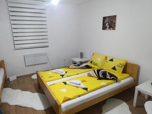 a bedroom with a yellow bed with yellow sheets at Apartman Maric in Drvar