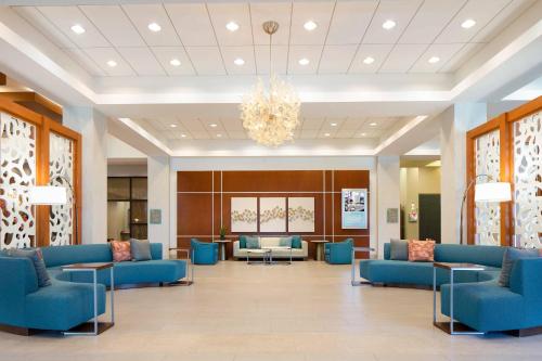a lobby with blue couches and tables and a chandelier at The Westin Lake Mary, Orlando North in Lake Mary