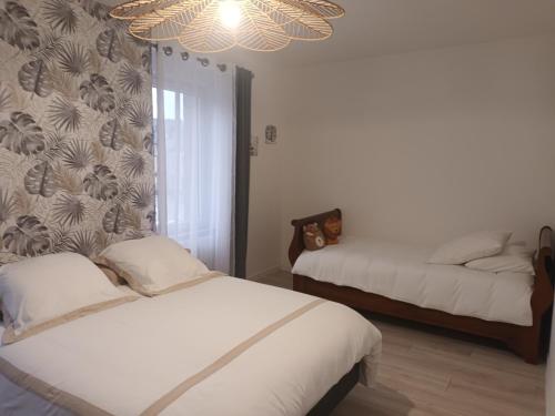 une chambre avec deux lits et un lustre dans l'établissement Magnifique Duplex Gîte Gambetta familial, à Ploumagoar