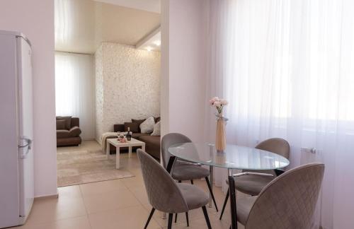 a dining room with a glass table and chairs at Apartment Obolon Natalka Park in Kyiv