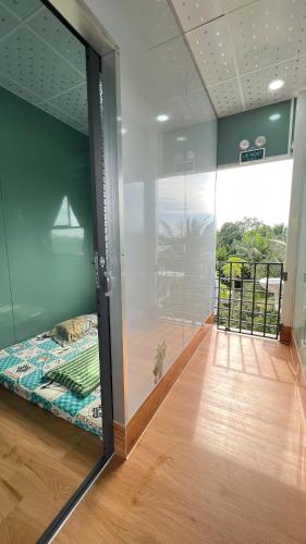 a room with a glass wall with a bed in it at HOMESTAY Hoàng GIa in Ấp Ông Tú