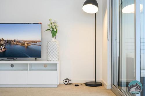 a living room with a television and a vase of flowers at Aircabin - Gordon - Modern - 2 Beds Apt Free Park in Gordon