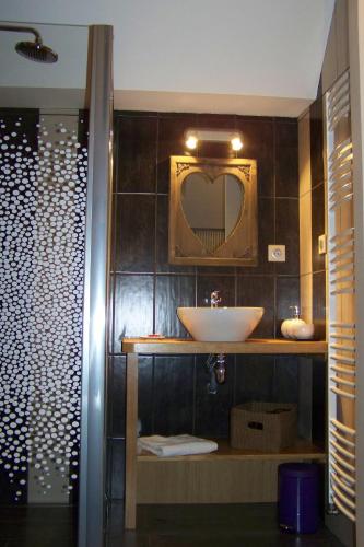 une salle de bain avec un lavabo et un miroir dans l'établissement Les Hôtes du Lac, Chambres et tables d'hôtes, à Mandailles