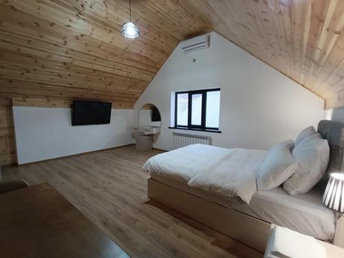 a bedroom with a large bed and a wooden ceiling at A Frame Houses in Sheki