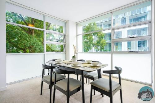 a dining room with a table and chairs and windows at Aircabin - Gordon - Modern - 2 Beds Apt Free Park in Gordon