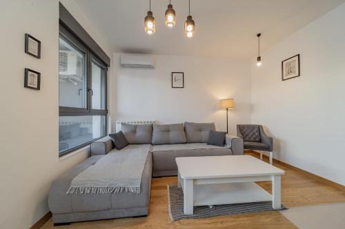 a living room with a couch and a table at Vozdove Kapije Belgrade Apartment Studio in Voždovac