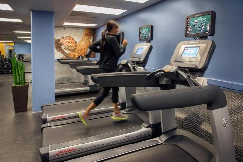 a woman running on a treadmill in a gym at Torrance Marriott Redondo Beach in Torrance