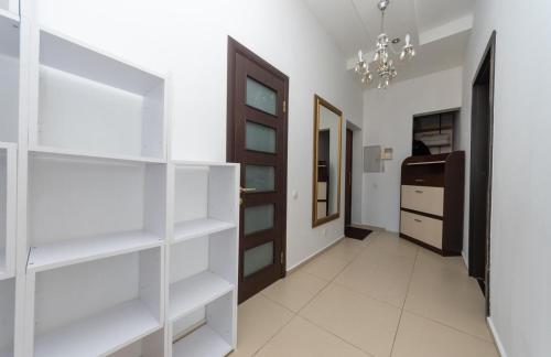 a hallway with white shelves and a door at Apartment Obolon Natalka Park in Kyiv