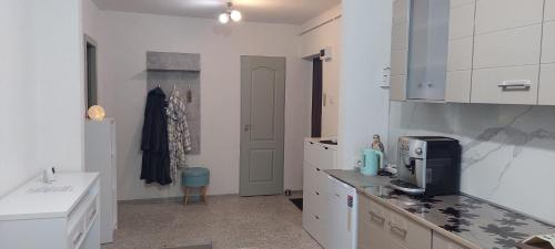 a kitchen with white cabinets and a counter top at Garsonieră la Anca Lupeni-Straja in Lupeni