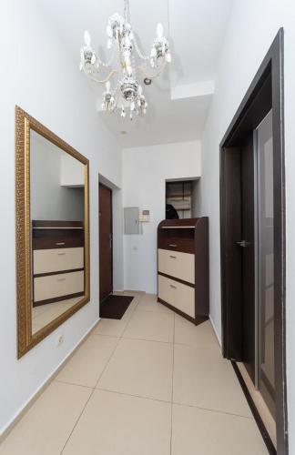 a hallway with a mirror and a chandelier at Apartment Obolon Natalka Park in Kyiv