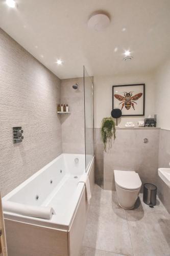 a bathroom with a tub and a toilet and a sink at The Rutland Hotel & Apartments in Edinburgh