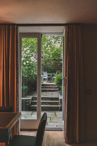an open door to a patio with a table and chairs at The Rutland Hotel & Apartments in Edinburgh