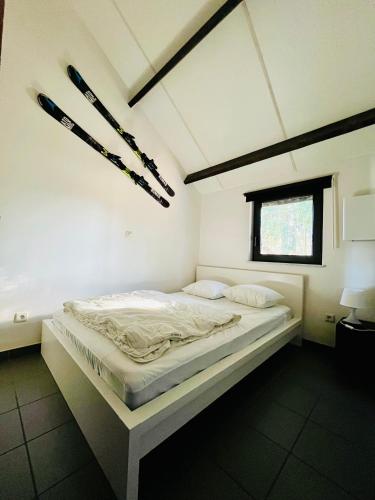 a large bed in a room with a window at Maison des M in Houffalize
