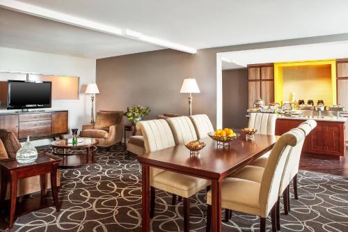 a hotel room with a table and a living room at Sheraton Harrisburg Hershey Hotel in Harrisburg