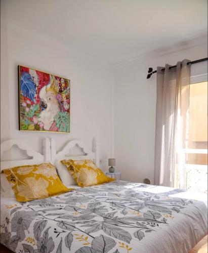 a bedroom with a bed with a painting on the wall at El Sultán 71 Corralejo in Corralejo