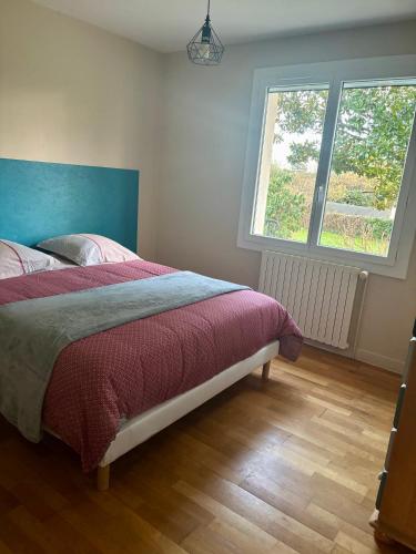 une chambre avec un lit et une fenêtre dans l'établissement A proximité du futuroscope et des marais poitevin, à Rouillé
