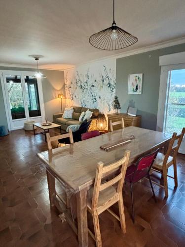 un salon avec une table, des chaises et un canapé dans l'établissement A proximité du futuroscope et des marais poitevin, à Rouillé