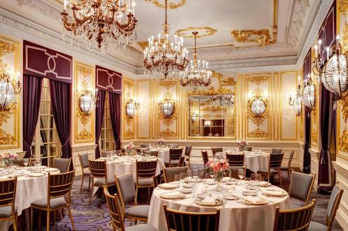 a dining room with tables and chandeliers at The St. Regis New York in New York