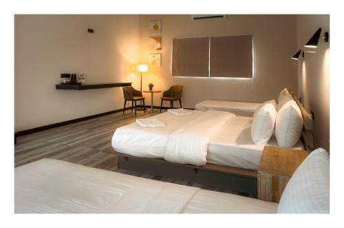 a hotel room with two beds and a table at Airport Green Olive Villa in Katunayaka