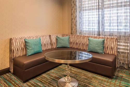 a brown leather couch with blue pillows and a table at Residence Inn Pittsburgh North Shore in Pittsburgh