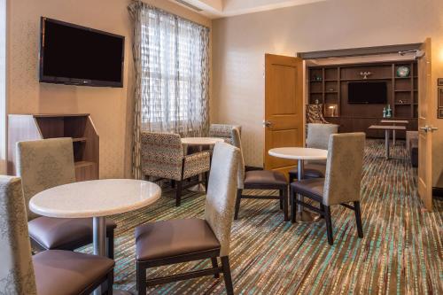 a hotel room with tables and chairs and a flat screen tv at Residence Inn Pittsburgh North Shore in Pittsburgh